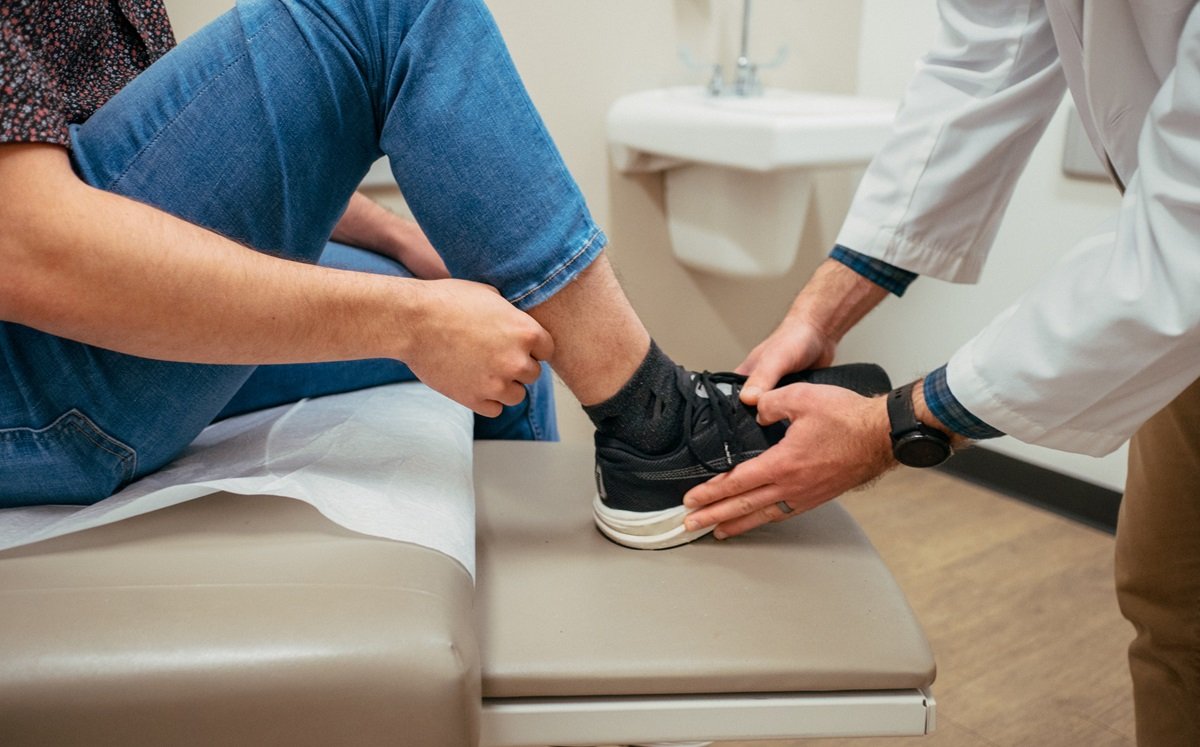 Medical provider examining ankle injury
